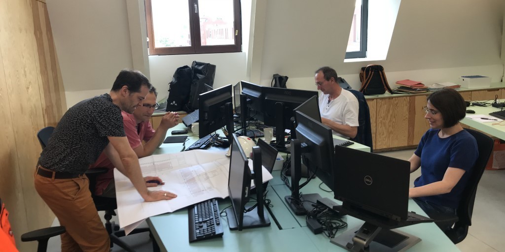 Collega's Lieven, Stefan, Ben en Ann aan hun werkplek Collega's Lieven, Stefan, Ben en Ann aan hun werkplek